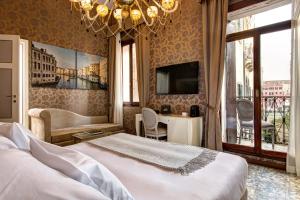 a hotel room with a bed and a chandelier at GKK Exclusive Private suite Venezia in Venice