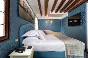 a bedroom with a bed with blue walls at GKK Exclusive Private suite Venezia in Venice