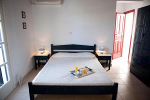 a bedroom with a bed with a tray of food on it at Elisso's Philoxenia in Agios Prokopios