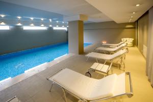 a room with four beds and a swimming pool at Hotel Atrium in Split