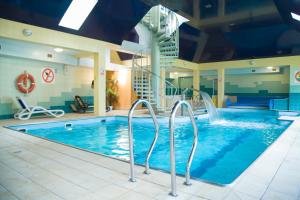 a large pool with a water slide in a hotel room at Hotel Morskie Oko in Jurata