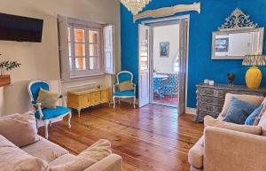 sala de estar con paredes azules y sillas azules en A Barca Charm House, en Sintra