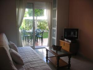 a living room with a couch and a television and a table at Urbanización Naturista Torremar Natura in Vera