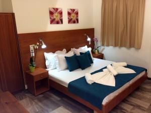 a bedroom with a bed with blue and white pillows at Creta Sun Studios in Kato Daratso