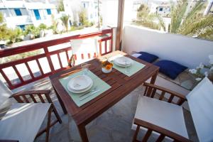 y balcón con mesa y sillas de madera. en Elisso's Philoxenia, en Agios Prokopios