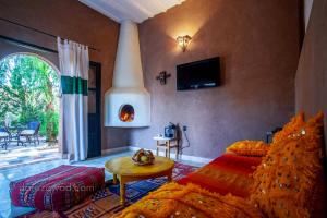 - un salon avec un lit et une cheminée dans l'établissement Dar Azawad, à M'Hamid El Ghizlane