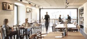 a group of people sitting at tables in a restaurant at Hotel Bären in Mellau