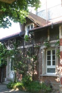 ein Backsteinhaus mit einer weißen Tür und Fenstern in der Unterkunft Les Hauts du Plateau in Châtillon