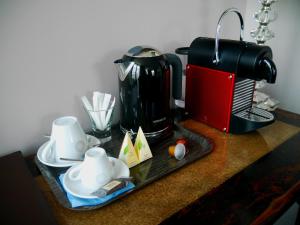 a table with a coffee maker and a coffee pot at AUBERGE DU CHÂTEAU BLEU in Tremblay En France