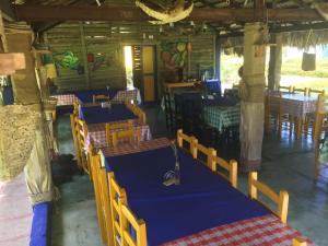 a restaurant with tables and chairs in a room at Los Bohios Campo Añil in Jarabacoa