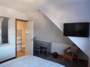 a bedroom with a bed and a tv on the wall at Shore to Shore in Llandudno