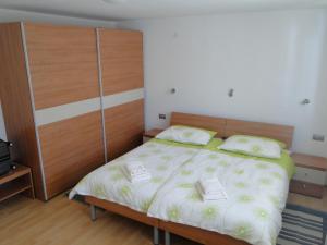 a bedroom with a large bed with a wooden headboard at Apartma Jezero in Most na Soči