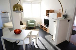 a living room with a table and a white refrigerator at Mid Mod in Cantù