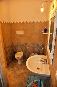 een badkamer met een witte wastafel en een toilet bij Villino Belvedere in Budoni