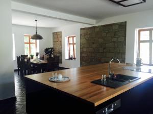 a kitchen with a wooden counter top with a sink at Prázdninový dům Vila 12 in Hořovičky +14 photos