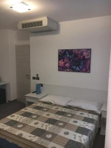 a bedroom with a bed and a picture on the wall at B&B Le Farfalle in Onno