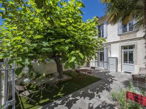 a courtyard with a tree and a table and chairs at La Sauternaise, luxury Boutique B&B in Sauternes