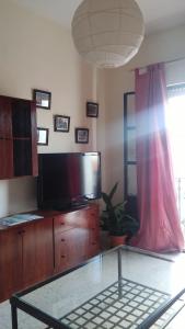 uma sala de estar com uma televisão e uma mesa de vidro em Apartamento Zulema em Aracena