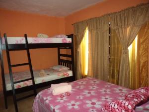 a bedroom with two bunk beds and a chair at Posada Nativa Shingle Hill in San Andrés