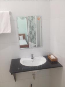 a bathroom with a sink and a mirror at Khách Sạn Đào Nguyên in Tuy Phong