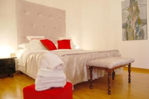 una camera da letto con un letto con cuscini rossi e bianchi di Casa del Bernini a San Quirico dʼOrcia