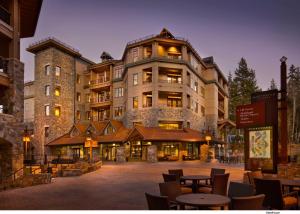 a large building with tables and chairs in front of it at The Residences at One Village Place by Hyatt Vacation Club in Truckee