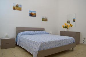 マティーノにあるLa Terra del Sole Casa privata per vacanzeのベッドルーム1室(青い掛け布団付きのベッド1台付)