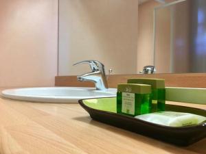 a bathroom counter with a sink and a mirror at Hôtel La Clairière in Chambon-sur-Dolore