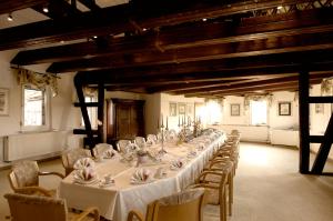 a long table in a room with tables and chairs at Adler Golf-& Tagungshotel in Harth - Pöllnitz