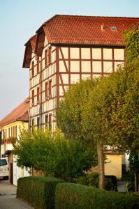 ein großes Gebäude mit rotem Dach auf einer Straße in der Unterkunft Adler Golf-& Tagungshotel in Harth - Pöllnitz