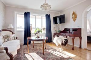 a living room with a table and a piano at Hotell & Restaurant Solliden in Stenungsund