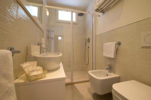 un bagno con doccia, WC e lavandino di Hotel Gambrinus Mare a Cattolica Altre 37 foto