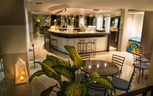 a bar in a restaurant with a table and chairs at Fantinello Hotel in Caorle