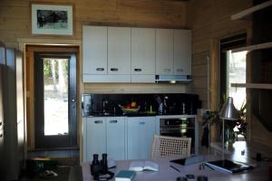 eine Küche mit weißen Schränken und einem Tisch darin in der Unterkunft Refuge du Cap in Baie-Saint-Paul