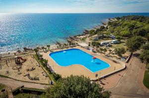 an overhead view of a swimming pool next to the ocean at FKK Ulika - Naturist Mobile Homes Eden in Poreč