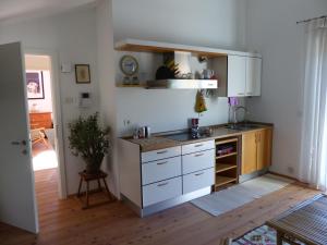 a kitchen with white cabinets and a counter top at Casa Clima Tandem in Denno