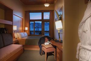 a hotel room with a bed and a window at Sunshine Mountain Lodge in Banff