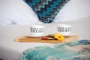 サニービーチにあるMercury Hotel-Premium All Inclusiveのベッドの上の木製トレイにコーヒーカップ2杯