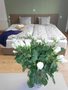 Un dormitorio con una cama con un jarrón de flores blancas en Dan In'n Out en Viena