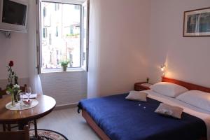 a bedroom with a bed and a table and a window at Apartments Nerio in Dubrovnik