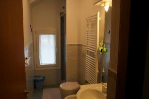 een badkamer met toilet, wastafel en raam bij Ca' Delle Erbe in Venetië +9 foto's