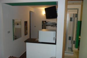 Zimmer mit einer Küche mit einer Theke und einem TV in der Unterkunft Alla Finestra Sul Parco in Cefalú