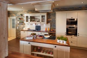 a kitchen with white cabinets and a wooden counter top at Hotel Garni Dorfkammer in Olsberg