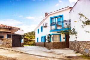 a white and blue house with a balcony at Casa Tenerías in Marchagaz