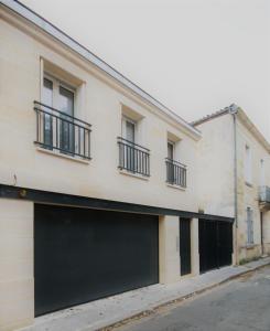 un bâtiment avec deux portes de garage dans une rue dans l'établissement La Villa Verte, à Bordeaux