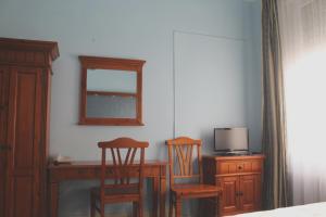 a bedroom with a desk and two chairs and a mirror at Hotel Am Roonplatz in Bonn