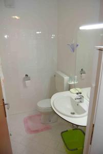 a white bathroom with a sink and a toilet at Vila Park in Rogaška Slatina