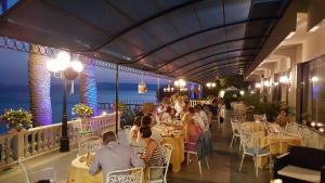 a group of people sitting at tables in a restaurant at Hotel Royal in Bolsena