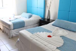 una camera d'albergo con due letti con asciugamani sopra di Villas Privadas en Palma Real a El Corazón
