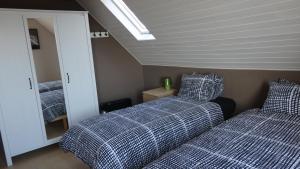 a bedroom with two beds and a mirror at B&B De Gastfabriek in Tielt